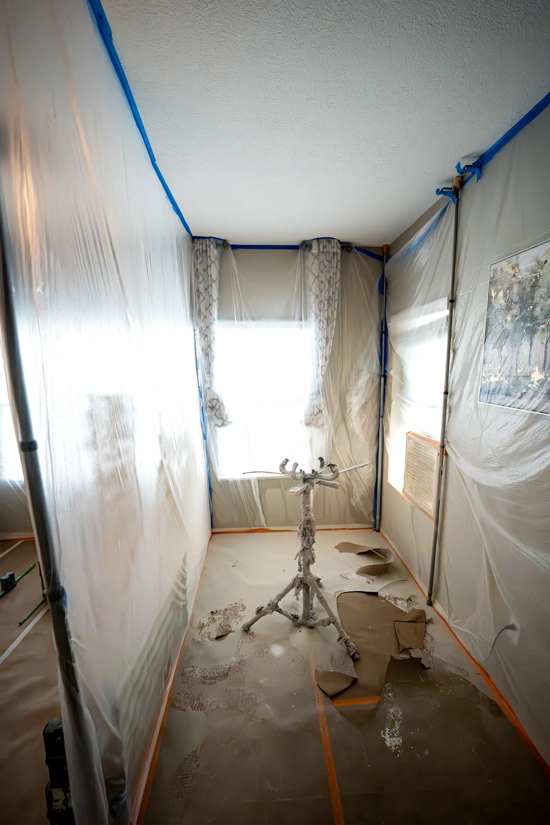 Kitchen masked in plastic sheeting during a cabinet refinishing project