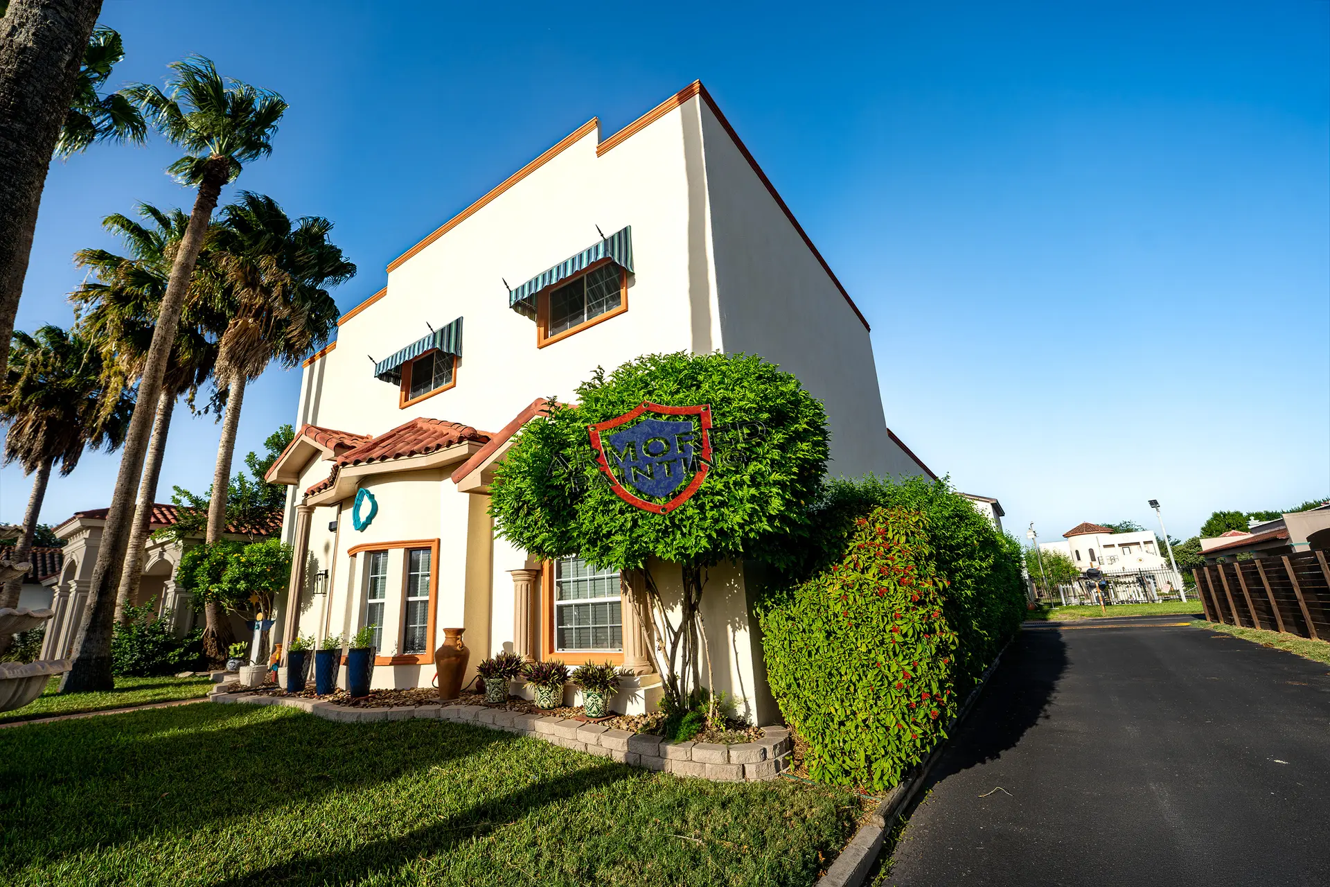 Two-story stucco home framed by palms after exterior painting